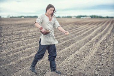 Genç bir köylü tahıl alanıyla sows