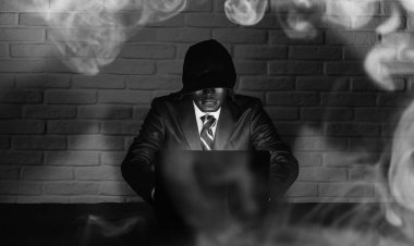 Siyah maske ve hood masada hacker