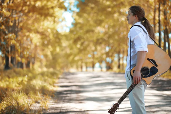Man with guitar in autumn day — Stock Photo, Image