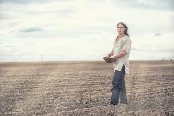 Genç bir köylü tahıl alanıyla sows