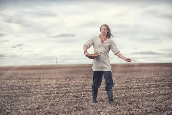 Genç bir köylü tahıl alanıyla sows