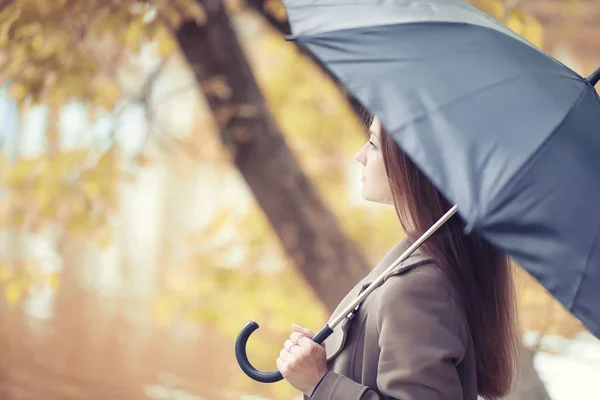 Giovane ragazza in un cappotto nel parco autunnale — Foto Stock