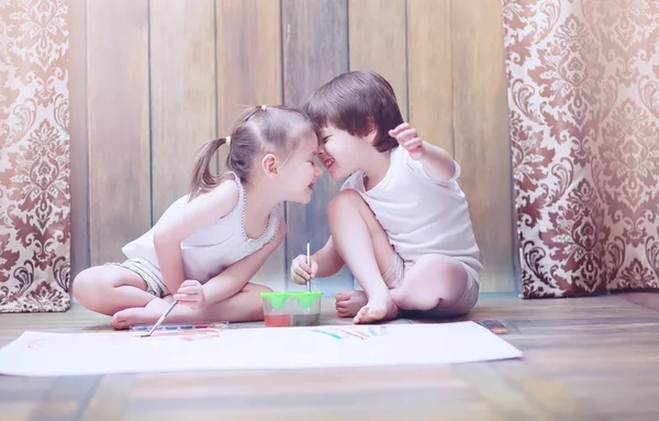 Petits enfants peignent sur une grande feuille de papier — Photo