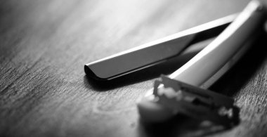 Tehlikeli bir ustura ve masanın üzerinde metal bir bıçak. Mens tıraş 