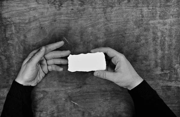Fekete-fehér fénykép tartó fehér üres papírlapot férfi kezek — Stock Fotó