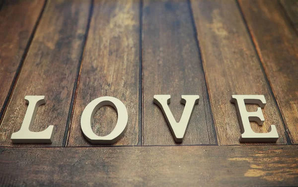 Слово Любовь из деревянных букв на заднем плане — стоковое фото