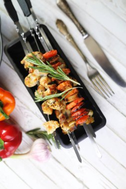 Pişmiş sebze ile metal şiş üzerinde kebap