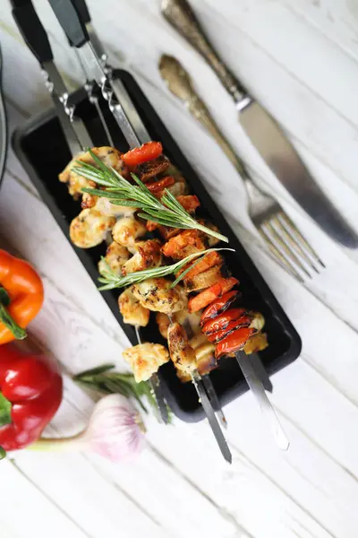 Pişmiş sebze ile metal şiş üzerinde kebap