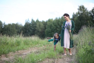 Anne ve kızı yolda yürüyor.