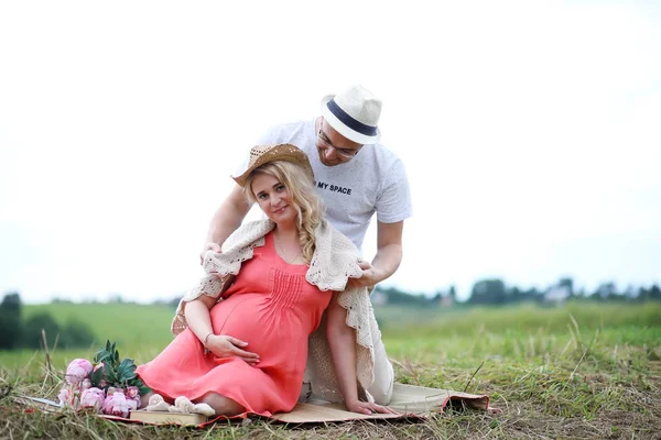 Schwangere Mädchen mit dickem Bauch und junger Mann im Freien — Stockfoto