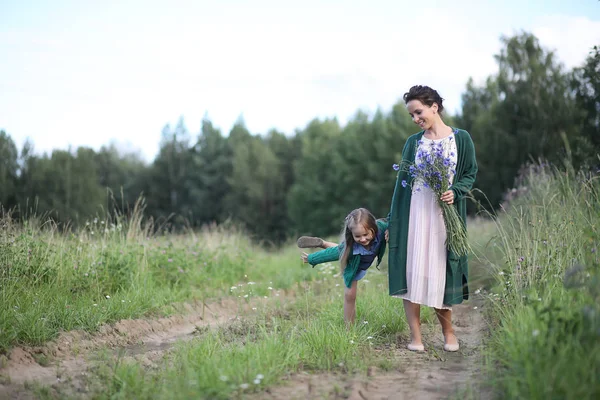 Anne ve kızı yolda yürüyor.