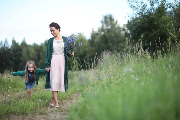 Anne ve kızı yolda yürüyor.