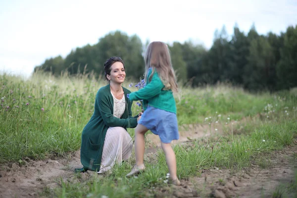 Anne ve kızı yolda yürüyor.