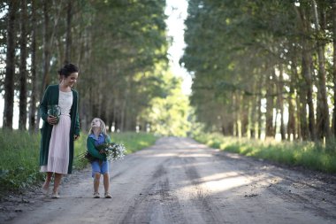 Anne ve kızı yolda yürüyor.