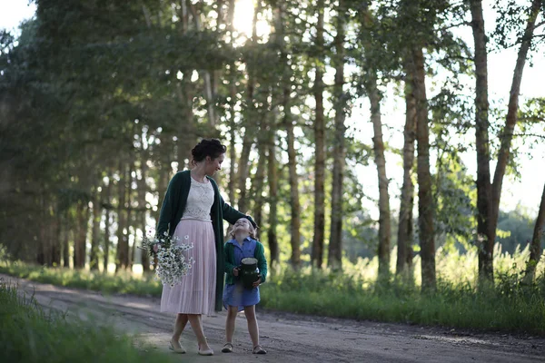 Madre con hija caminando por un camino — Foto de Stock