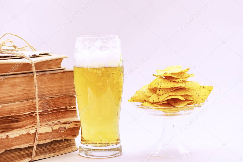 A stack of vintage books and a mug of light beer