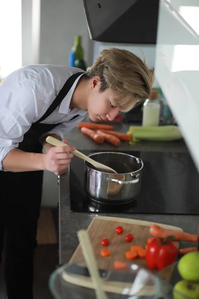 Asian cook in the kitchen prepares food in a cook suit