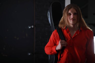 Bir gitar ile uzun saçlı Genç adam