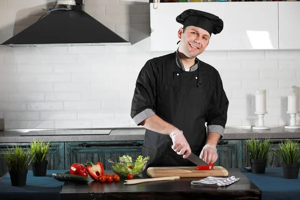 Man cook preparing food at the kitchen of vegetables