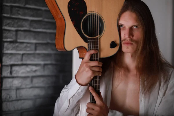 Jovem com cabelo comprido e guitarra — Fotografia de Stock