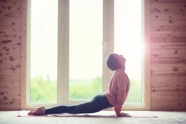 Flicka i yogaställningarna på golvet — Stockfoto