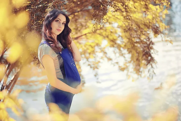 Mulher grávida em um passeio no parque — Fotografia de Stock