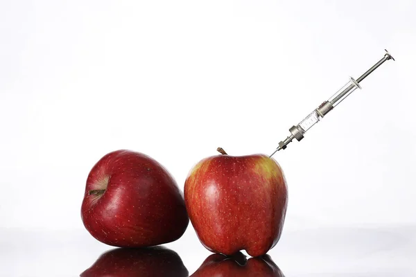 Alimentos modificados genéticamente, manzana bombeada con productos químicos — Foto de Stock