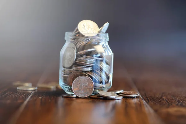 Coins in a glass jar on a wooden floor. Pocket savings from coin — Stock Photo, Image