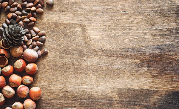 Verschiedene Nüsse auf einem Holztisch. Zeder, Cashew, Haselnuss, Walnuss — Stockfoto