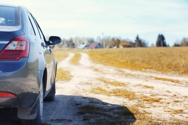 El coche está estacionado en el campo de otoño. El coche está conduciendo. — Foto de Stock