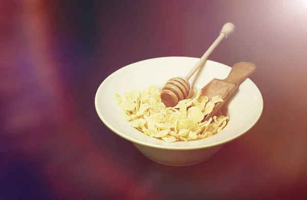 Cornflakes in einem Teller. Frühstück aus Flocken mit Honig und Mil — Stockfoto