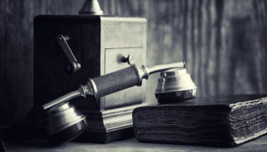 Eski telefon ve retro kitap masanın üzerinde. Geçmişte telefon 
