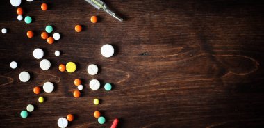 Uyuşturucu ve hap ahşap bir masa üzerinde. Soğuk algınlığı önlemek için çeşitli demektir. Çay limon ve bal ile. Cam bardak çay dilim limon ve bir kavanoz bal ile.