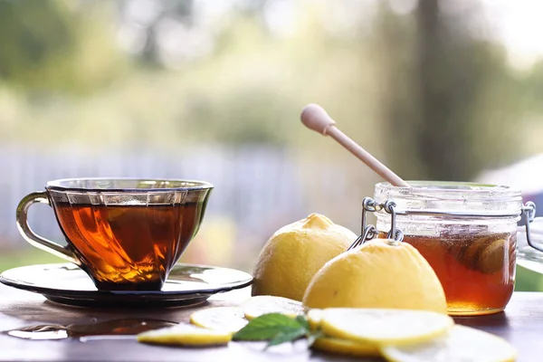 Frischer Honig mit einer Tasse Schwarztee — Stockfoto