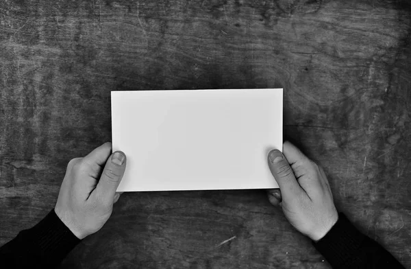 紙の白い空白のシートを保持しているモノクロ写真男性の手 — ストック写真
