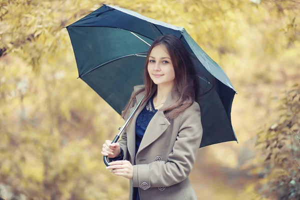 Jeune fille dans un manteau dans le parc d'automne — Photo