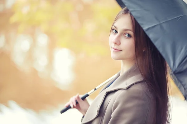 Giovane ragazza in un cappotto nel parco autunnale — Foto Stock