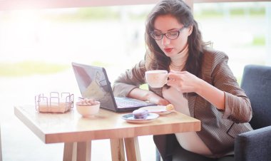 Kafede bilgisayarda çalışan hamile kadın