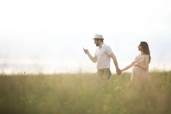 Paar Mann und schwangere Mädchen auf dem Feld — Stockfoto