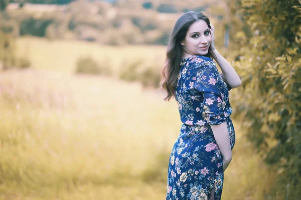 Gravid flicka i en klänning i naturen — Stockfoto