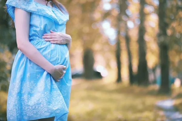 Gravid flicka i en klänning i naturen — Stockfoto