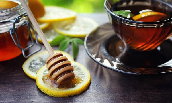 Tee mit Zitrone und Minze in der Natur. eine Tasse heißen Minztee mit le — Stockfoto