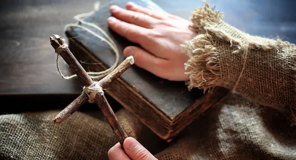 Livro velho religioso em uma mesa de madeira. Uma cruz religiosa amarrado sagacidade — Fotografia de Stock