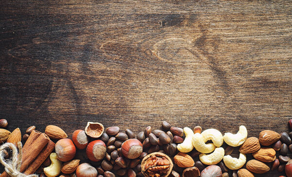 Different nuts on a wooden table. Cedar, cashew, hazelnut, walnu