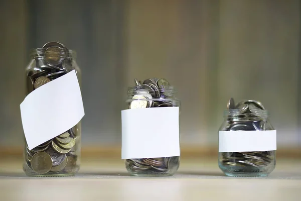 Accumulated coins stacked in glass jars — Stock Photo, Image