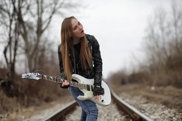 Дівчина рок-музиканта в шкіряній куртці з гітарою — стокове фото