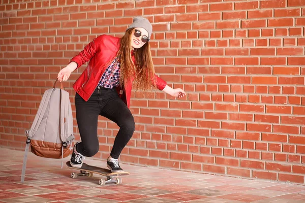 Ένα νεαρό hipster κορίτσι είναι ιππασίας ένα skateboard. Κορίτσια φίλες f — Φωτογραφία Αρχείου