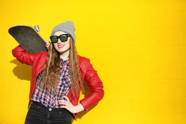 A young hipster girl is riding a skateboard. Girls girlfriends f