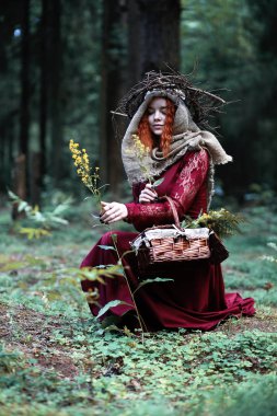 Kızıl saçlı cadı bir ritüel bir kristal top ile tutar