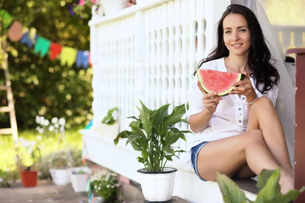 Flicka på en trä veranda med vattenmelon — Stockfoto